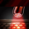 Primer plano de un dispositivo masajeador facial con luz roja iluminando el tejido de la piel.