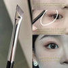A close-up of an angled makeup brush demonstrating how to draw lines for eye makeup application.