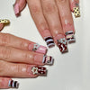 A hand displays a set of 24 press-on coffin nails featuring various patterns including polka dots, stripes, and stars.