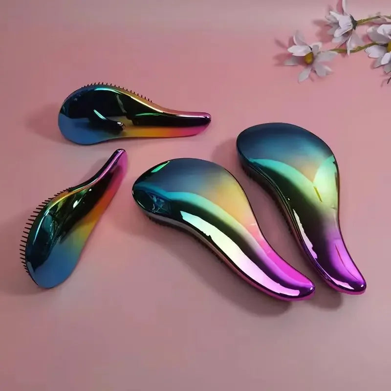 A set of three iridescent silicone detangling hair brushes displayed on a pink background.