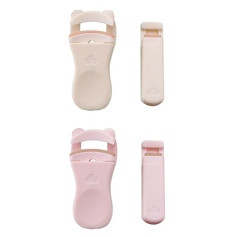 A pair of pink and beige cartoon mini eyelash curlers shown in different orientations.