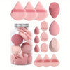 A collection of 15 pink makeup sponges in various shapes and sizes displayed next to a glass jar.