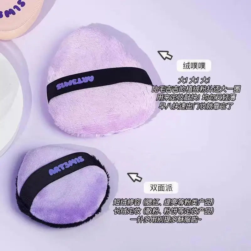 Un soufflet cosmétique violet à la poudre et un objet ressemblant à une balle de tennis violet et noir.
