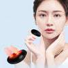 A woman is using a portable infrared nasal therapy device on her nose with her fingers.