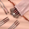 A collection of 13 professional makeup brushes in various shades and sizes laid out on a light background.