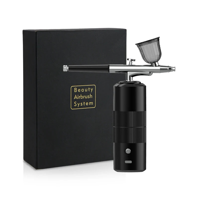 A black box and a silver beauty airbrush system with a clear nozzle are displayed on a white surface.