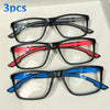 Tres pares de gafas de lectura rectangulares vintage en marcos negros, rojos y azules sobre fondo blanco.