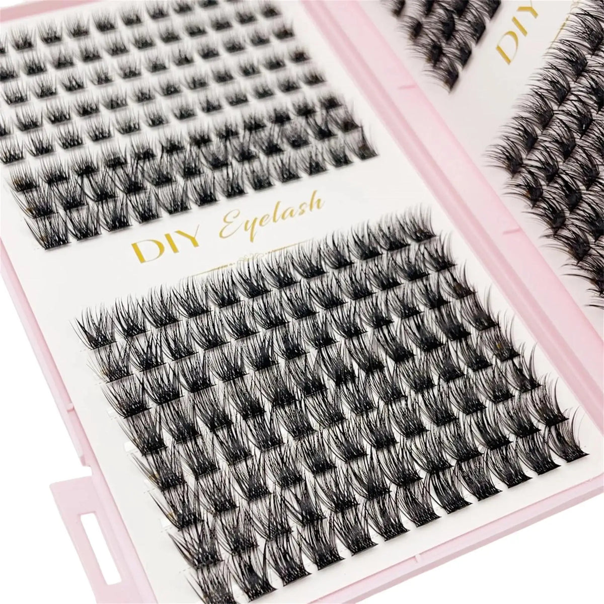 A close-up of a pink tray containing black bulk cluster eyelash extensions for DIY makeup application.