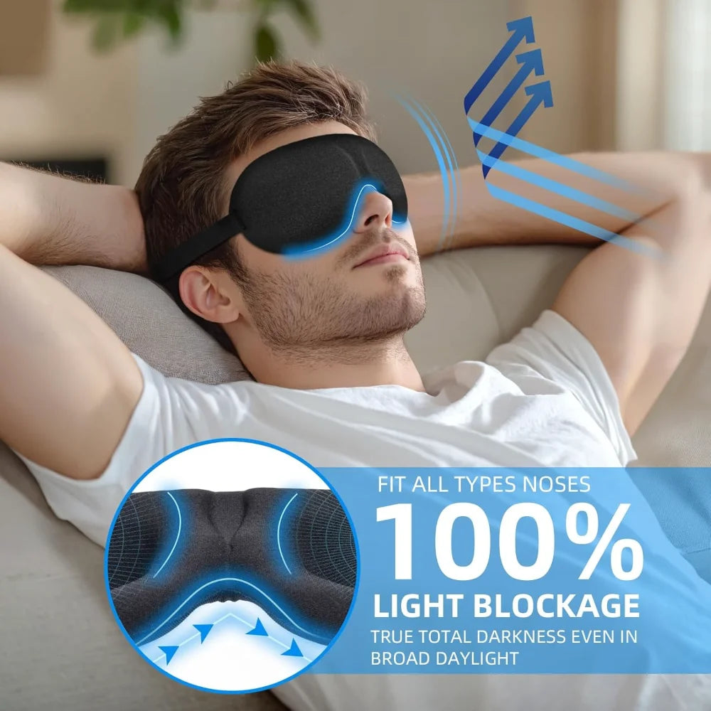 A man wearing a black 3D sleep mask for light blocking is relaxing indoors.