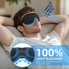 A man wearing a black 3D sleep mask for light blocking is relaxing indoors.