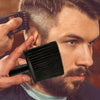 Ein Mann benutzt eine schwarze professionelle Haarbürste auf sein Gesicht und Hals.