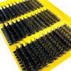 A yellow tray holding clusters of black faux lashes for dramatic eye looks.