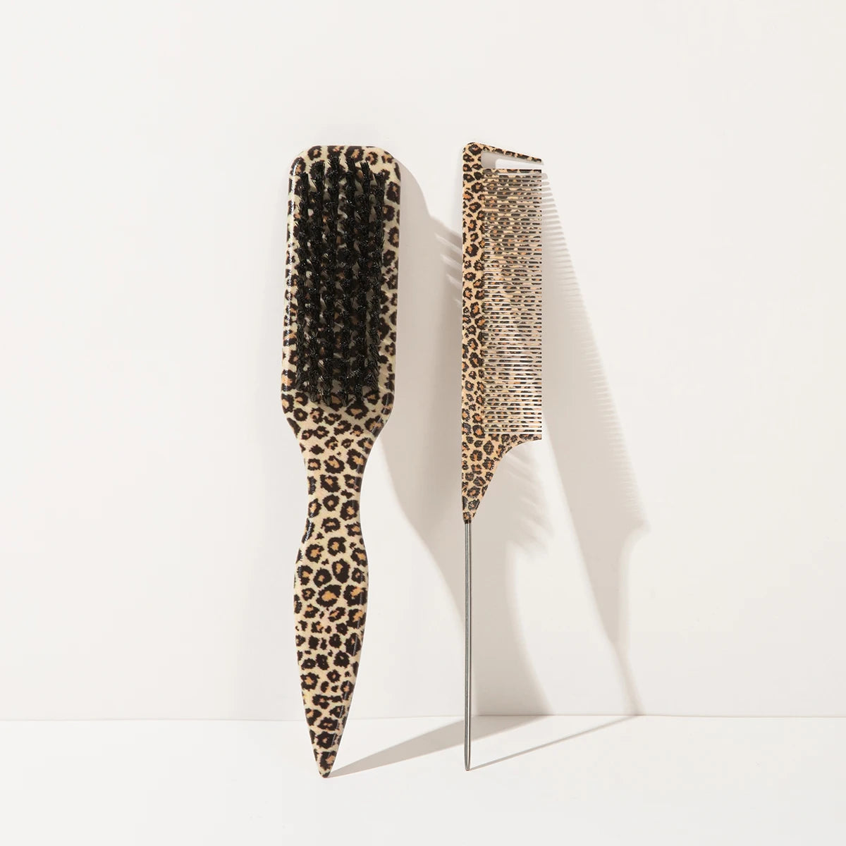 A set of two leopard print pointed tail hair combs displayed against a white background.