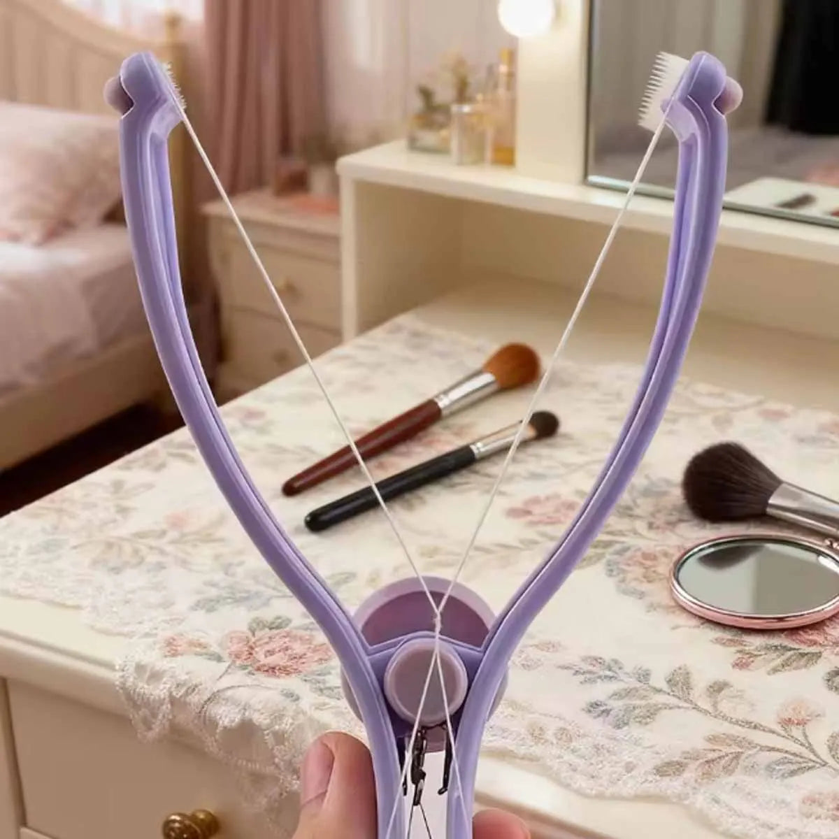 A hand holds a purple precision spring-action facial hair remover with attached brushes on a white surface.