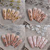 A collection of long, coffin-shaped nails decorated with multi-color 3D hibiscus flower nail decals on a textured gray backgr