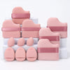 A set of twelve pink makeup sponges with pink bands arranged on a white surface.