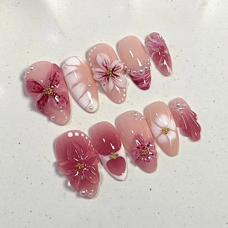 A collection of 24 press-on almond nails featuring pink and white floral and butterfly designs.