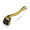 A gold-colored titanium micro derma roller tool with a handle and a textured roller head.