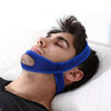 A man is wearing a blue anti-snoring chin strap while sleeping on a white pillow.
