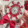 A hand holding a decorative makeup mirror set with a red ribbon and silver frame.