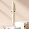 A professional automatic hair curling iron in cream and rose gold is displayed on a white surface.