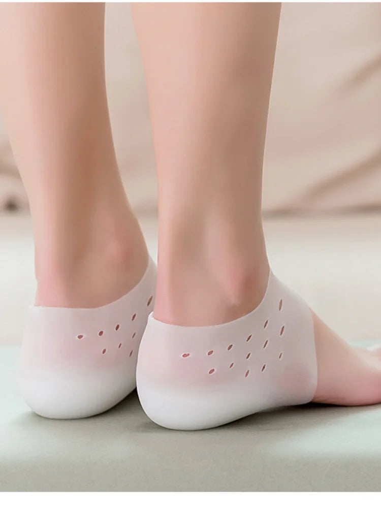 Une paire de semelles en silicone blanches posées sur le pied d'une personne.