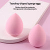 Two teardrop-shaped pink sponge eggs resting on a white surface.