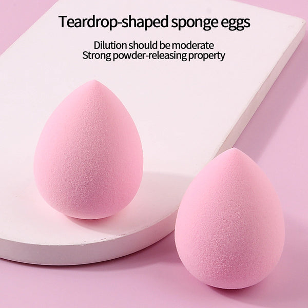 Two teardrop-shaped pink sponge eggs resting on a white surface.