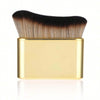 Cepillo portátil para bronceado corporal de color dorado con cerdas negras y rubias.