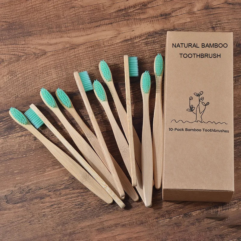 Une boîte de dix brosses à dents en bambou naturelles est exposée sur une surface en bois.