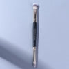 A long, double-ended eye shadow brush with a smudge tip and blending shader, shown vertically against a light gray background