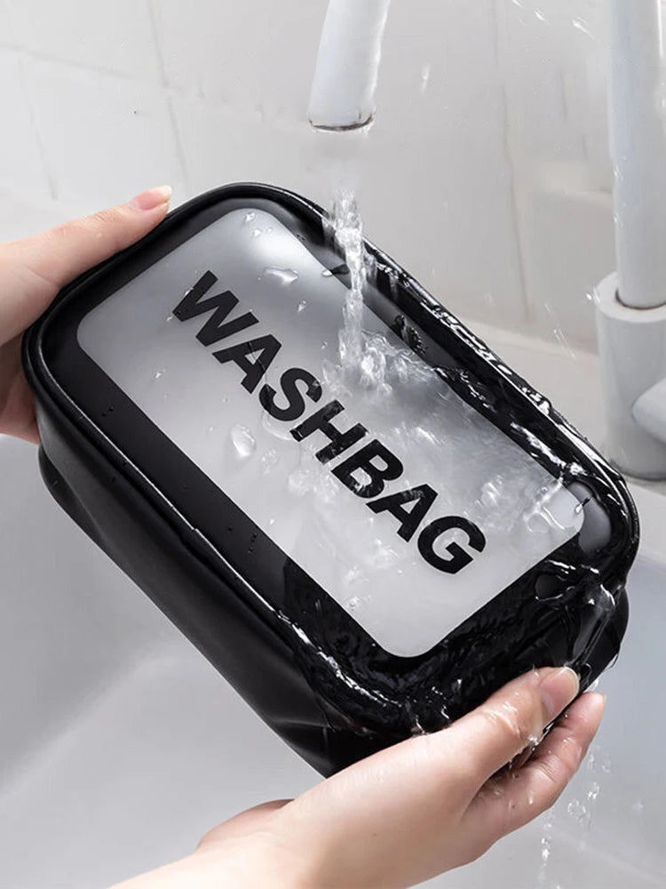 A hand is holding a black cosmetic storage bag filled with water, being rinsed under a faucet.