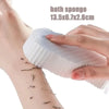 Eine Hand benutzt eine weiße Silikonschwamm zur Fußexfoliation und Massage.