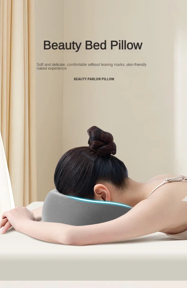 A woman is resting her head on a gray ergonomic memory foam pillow in a bright room.