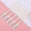 Five white double-headed manual nose hair trimmers arranged diagonally on a pink and white background.