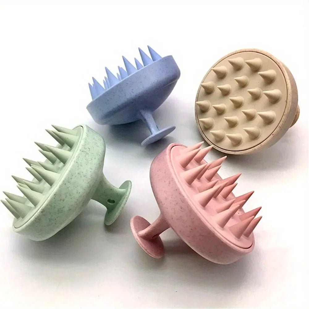 Three silicone massage brushes in blue, beige, and pink are displayed on a white surface.
