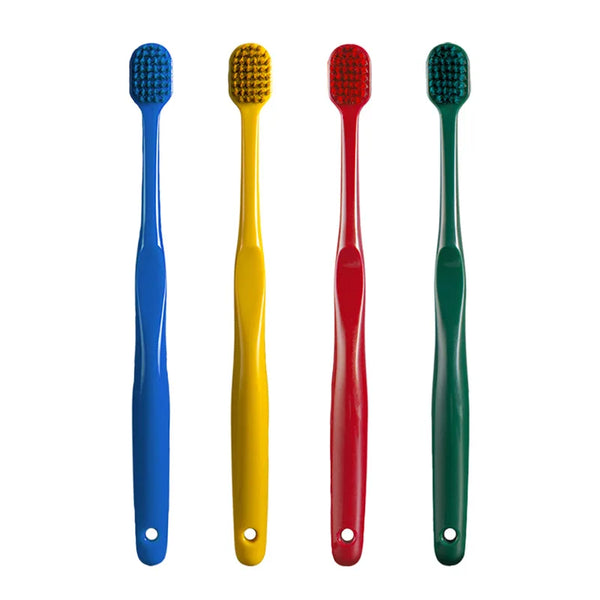 Un set de quatre brosses à dents de couleurs différentes (bleu, jaune, rouge, vert) avec différentes brins