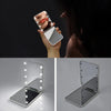 A hand holds a mini folding makeup mirror with an LED light, showing its folded and unfolded states.
