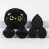 Un ensemble de poudre à tablier noire brodée, comprenant un applicateur en forme de chat et plusieurs poudres rondes.