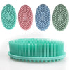 Quatre gants de douche en silicone à double face dans les couleurs sarcelle, rose, bleu et vert sont présentés au-dessus d'un