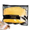 A black pouch of African Bath Sponge showing a yellow, net-like exfoliating sponge next to a person using it in a bathtub.