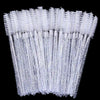A set of clear disposable eyelash and eyebrow brushes arranged vertically against a black background.