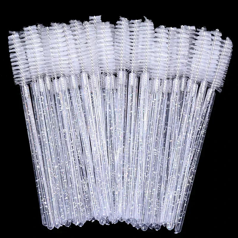 A set of clear disposable eyelash and eyebrow brushes arranged vertically against a black background.