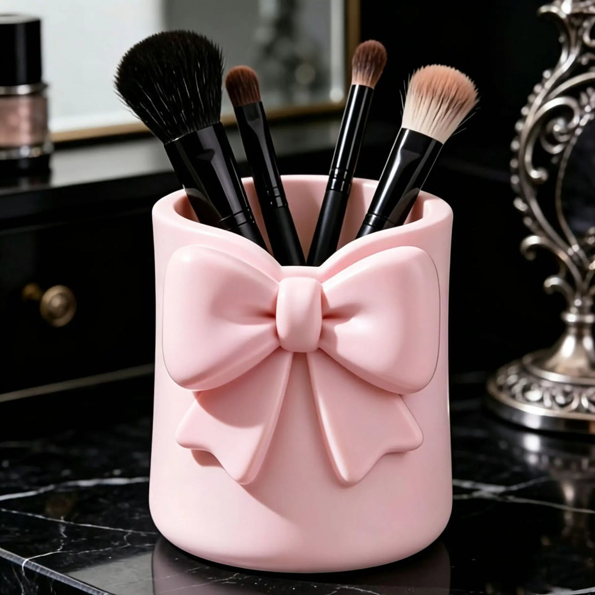 Organisateur de rangement rose contenant plusieurs pinceaux de maquillage sur une surface en marbre noir.