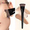 A black flat kabuki foundation brush with brown and gold bristles shown next to a model's face.