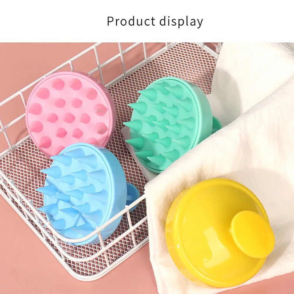 Présentation de brosses nettoyantes pour cuir chevelu en silicone roses, vertes et bleues dans un panier de fil blanc.
