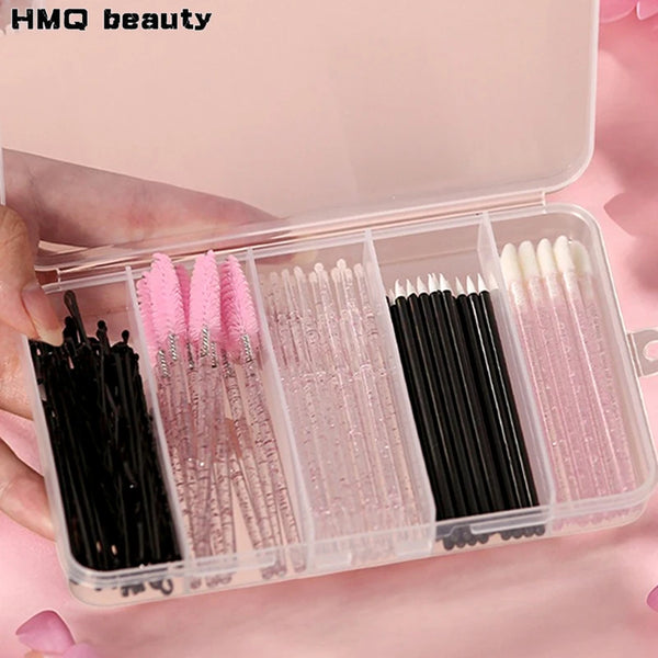 A clear storage case holds various makeup brushes and tools, including pink, black, and white synthetic bristles.