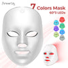 Una mascarilla facial blanca con siete luces LED de colores, junto a una versión roja.