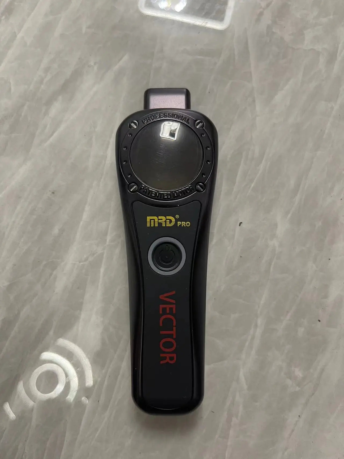 A black MRD Pro Vector electric hair trimmer is shown on a light surface.