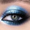 Primer plano de un ojo con sombra de ojos metálica azul brillante y con purpurina.